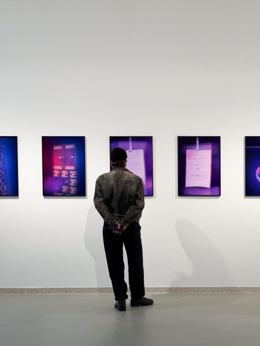 Person observing vibrant artwork by Aura, Mario Kiesenhofer in an art gallery.