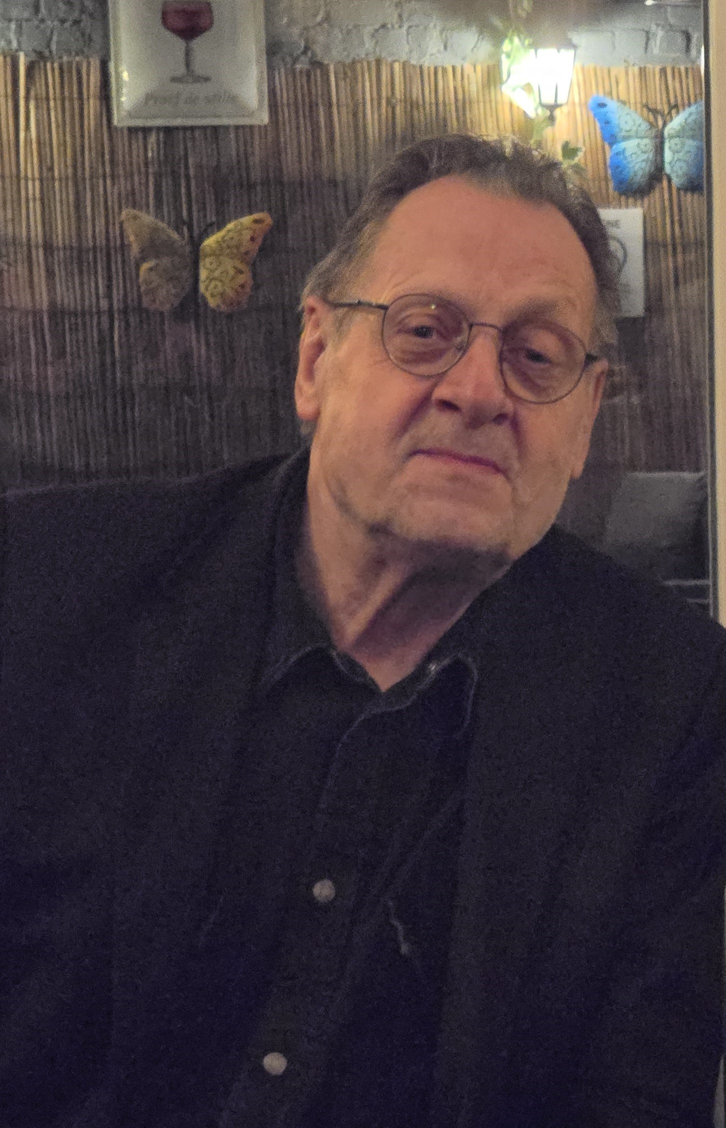 Porträt einer Person in einem gemütlichen Raum mit Schmetterlingsdekoration, möglicherweise in Martha's Labyrinth.