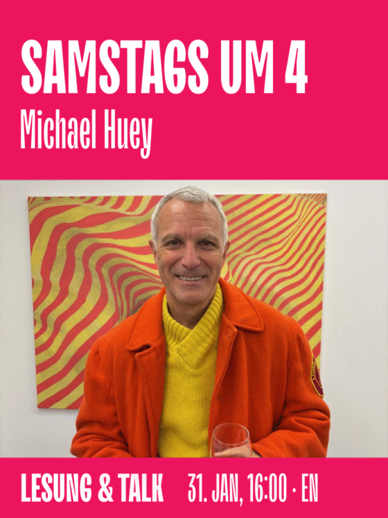 Michael Huey lächelt in orangefarbener Jacke vor einem bunten, abstrakten Hintergrund.