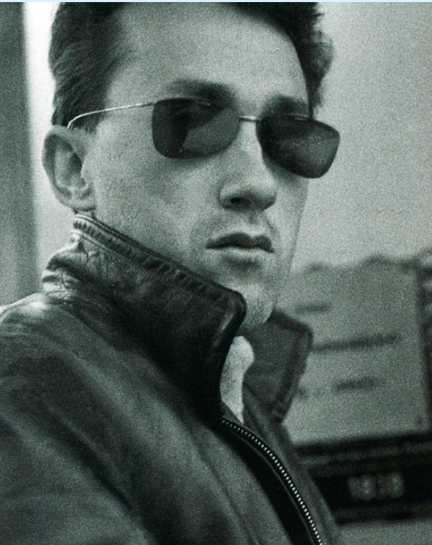 Porträt einer Person mit Sonnenbrille und Lederjacke, nachdenklicher Ausdruck, Nachmittag.