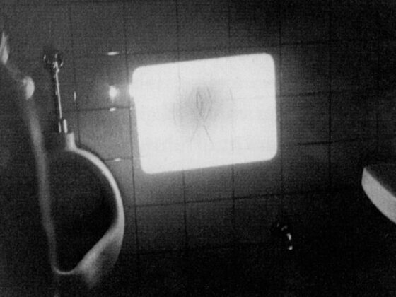 Bild eines Urinals mit reflektierendem Licht auf einer Wand, in einem Badezimmer.